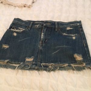 Torn and distressed denim mini skirt